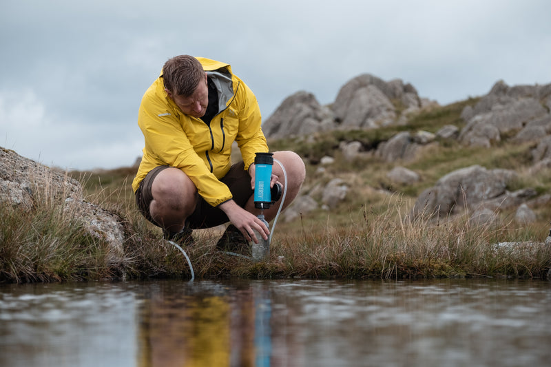 Carica immagine in Galleria Viewer, A man purifying lake water using a LifeSaver Liberty bottle
